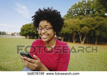 Mixed race woman text messaging on cell phone View Large Photo Image Stock Photo - Mixed race woman text messaging on cell phone. Fotosearch