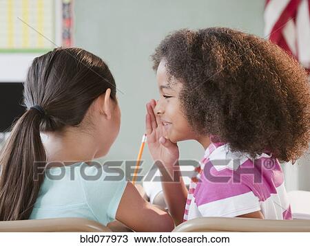 School girl whispering to friend View Large Photo Image Stock Image - School girl whispering to friend. Fotosearch