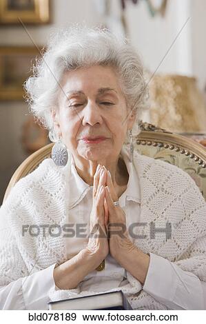 Senior Hispanic woman praying View Large Photo Image Stock Photo - Senior Hispanic woman praying. Fotosearch