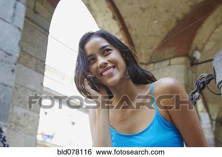 Stock Photograph - Thai woman talking on cell phone. Fotosearch