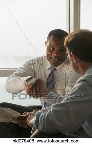 Stock Photo - Businessmen shaking hands in agreement. Fotosearch