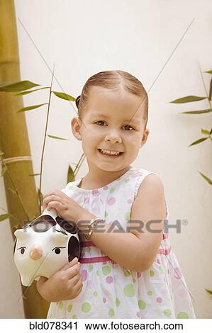 Hispanic girl holding piggy bank View Large Photo Image Stock Image - Hispanic girl holding piggy bank. Fotosearch