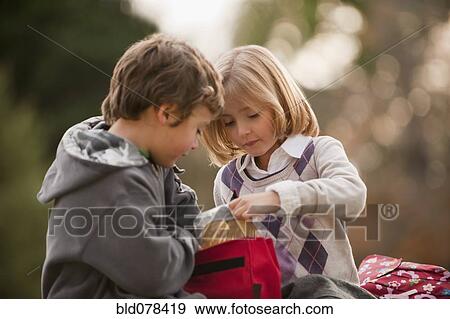 Stock Photo - Mixed race brother and sister eating lunch. Fotosearch