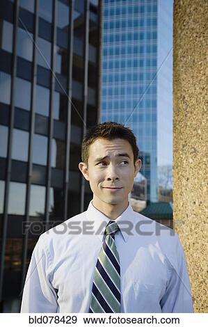 Stock Photo - Mixed race businessman standing outdoors. Fotosearch