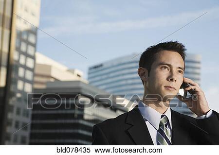 Stock Photography - Mixed race businessman talking on cell phone. Fotosearch