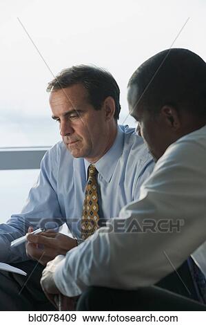 Stock Photo - Serious businessmen having meeting. Fotosearch