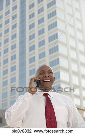 Black businessman talking on cell phone outdoors View Large Photo Image Stock Image - Black businessman talking on cell phone outdoors. Fotosearch