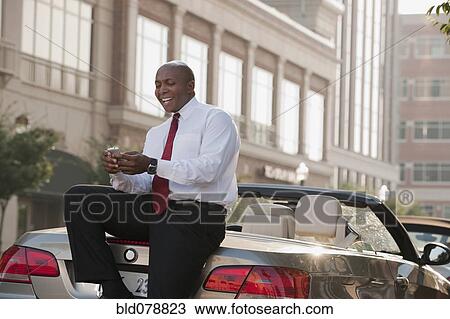 Black businessman text messaging on cell phone outdoors View Large Photo Image Stock Image - Black businessman text messaging on cell phone outdoors. Fotosearch