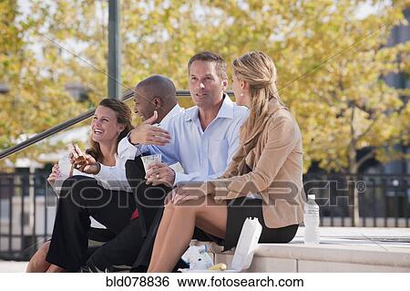 Stock Photograph - Business people eating lunch on steps. Fotosearch