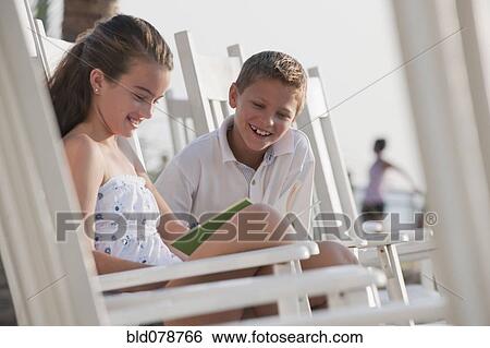 Stock Photograph - Caucasian boy and girl sitting in rocking chair. Fotosearch
