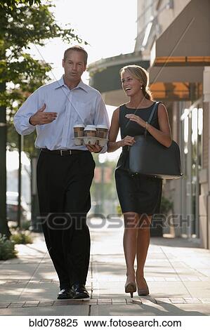 Caucasian business people carrying coffee for co-workers View Large Photo Image Stock Photography - Caucasian business people carrying coffee for co-workers. Fotosearch
