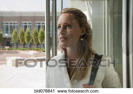 Stock Image - Caucasian businesswoman entering office building. Fotosearch