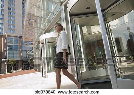 Stock Image - Caucasian businesswoman leaving office building. Fotosearch