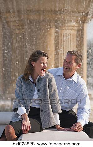 Caucasian couple laughing near spraying fountain View Large Photo Image Stock Photo - Caucasian couple laughing near spraying fountain. Fotosearch