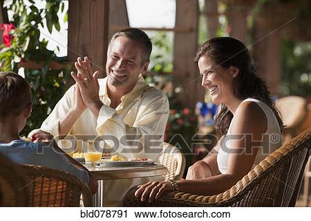 Stock Image - Caucasian family eating in restaurant. Fotosearch