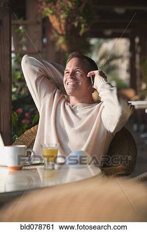 Caucasian man talking on cell phone in restaurant View Large Photo Image Stock Image - Caucasian man talking on cell phone in restaurant. Fotosearch