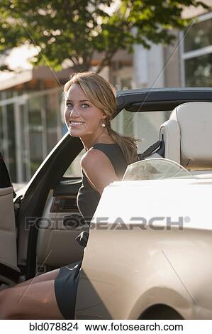 Caucasian woman getting out of convertible View Large Photo Image Picture - Caucasian woman getting out of convertible. Fotosearch