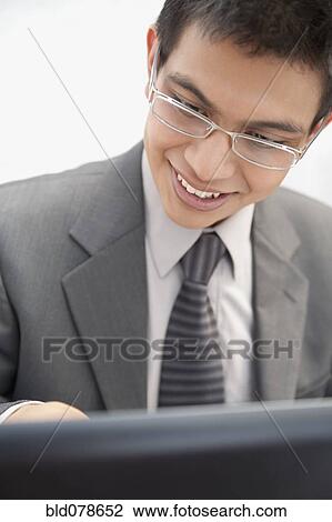 Hispanic businessman in eyeglasses looking at laptop View Large Photo Image Stock Image - Hispanic businessman in eyeglasses looking at laptop. Fotosearch