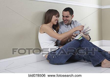 Stock Photograph - Hispanic husband and wife looking at color swatches. Fotosearch