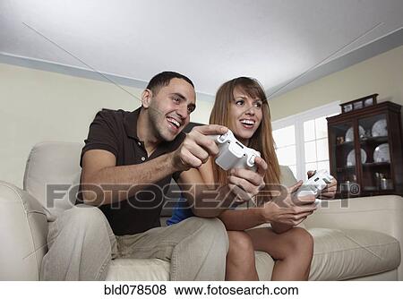 Stock Photo - Hispanic husband and wife playing video game. Fotosearch