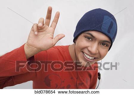 Hispanic man in cap listening to headphones and waving View Large Photo Image Picture - Hispanic man in cap listening to headphones and waving. Fotosearch