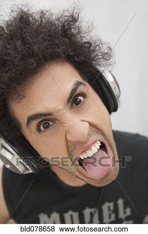 Hispanic man in headphones grimacing View Large Photo Image Stock Photo - Hispanic man in headphones grimacing. Fotosearch