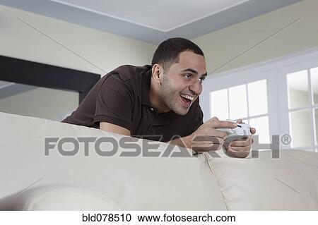 Hispanic man playing video game View Large Photo Image Stock Image - Hispanic man playing video game. Fotosearch