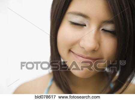 Stock Photo - Hispanic teenage girl smiling with eyes closed. Fotosearch