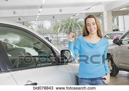 Stock Image - Hispanic woman holding keys to new car. Fotosearch