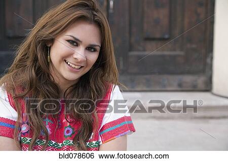 Stock Photograph - Hispanic woman sitting on door step. Fotosearch