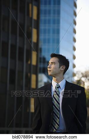 Picture - Mixed race businessman standing outdoors. Fotosearch
