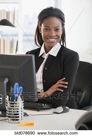 Mixed race businesswoman sitting at desk View Large Photo Image Stock Image - Mixed race businesswoman sitting at desk. Fotosearch
