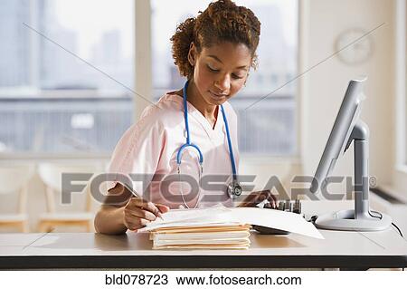 Mixed race nurse working on medical charts at computer View Large Photo Image Stock Image - Mixed race nurse working on medical charts at computer. Fotosearch