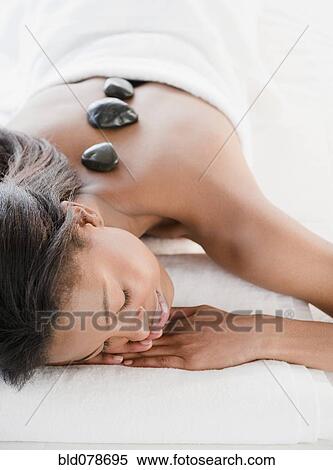 Mixed race woman having hot stone therapy View Large Photo Image Stock Photography - Mixed race woman having hot stone therapy. Fotosearch