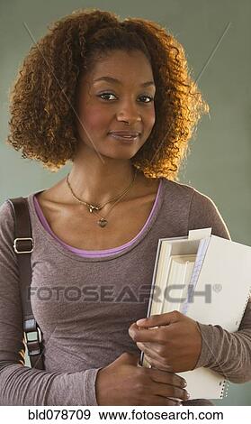 Stock Photo - Mixed race woman holding books. Fotosearch