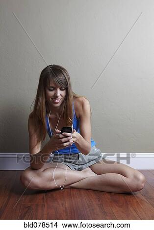 Picture - Mixed race woman listening to mp3 player. Fotosearch