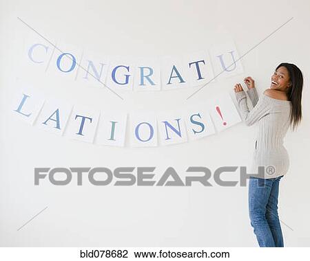 Mixed race woman putting up congratulations sign View Large Photo Image Stock Image - Mixed race woman putting up congratulations sign. Fotosearch