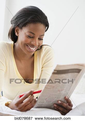 Mixed race woman reading classified ads View Large Photo Image Stock Photo - Mixed race woman reading classified ads. Fotosearch