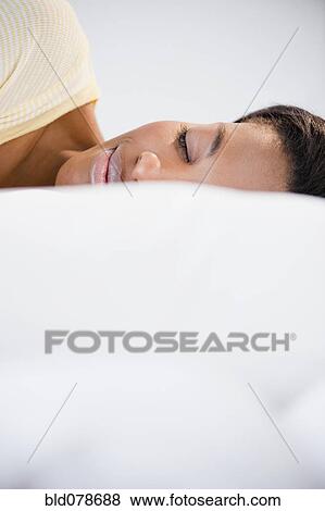 Stock Photo - Mixed race woman sleeping in bed. Fotosearch