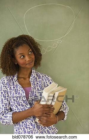 Mixed race woman standing next to thought bubble on blackboard View Large Photo Image Stock Photograph - Mixed race woman standing next to thought bubble on blackboard. Fotosearch