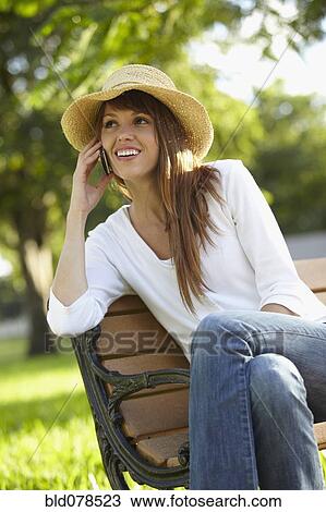 Stock Image - Mixed race woman talking on cell phone outdoors. Fotosearch