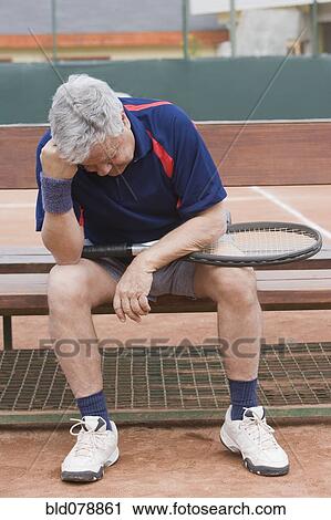 Stock Image - Senior Hispanic man unhappy after tennis game. Fotosearch