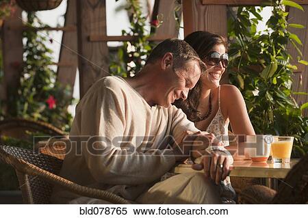 Stock Photography - Smiling couple eating in restaurant. Fotosearch