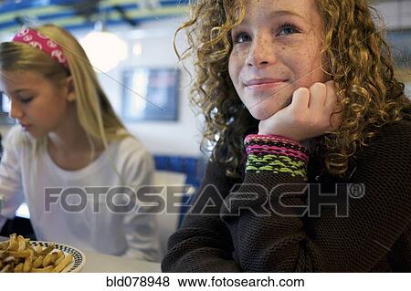 Stock Photo - Caucasian girls eating in cafe. Fotosearch