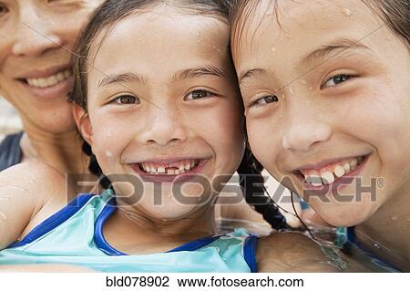 Stock Image - Family in pool smiling. Fotosearch