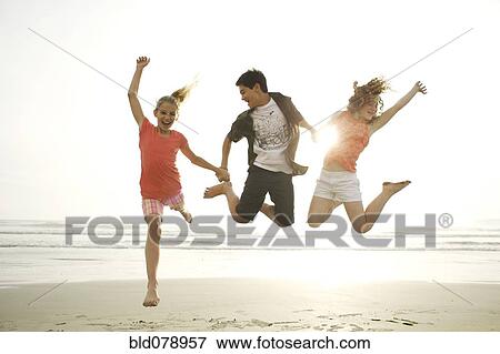Stock Photo - Friends playing on beach. Fotosearch