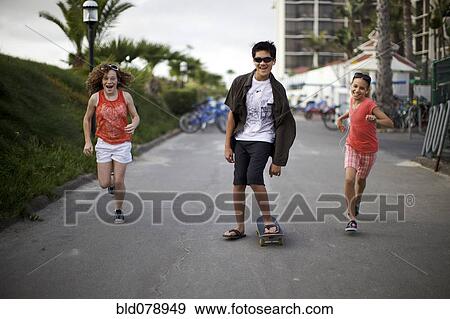 Stock Photo - Friends walking along urban sidewalk. Fotosearch