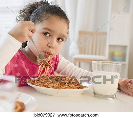 Stock Photo - Hispanic girl eating spaghetti. Fotosearch