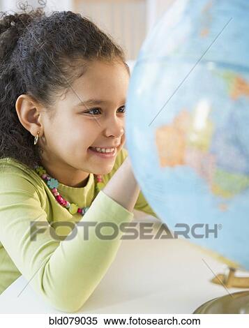 Stock Photography - Hispanic girl looking at globe. Fotosearch