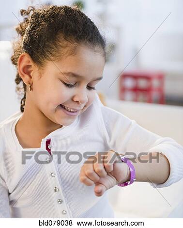 Hispanic girl looking at wristwatch View Large Photo Image Stock Photo - Hispanic girl looking at wristwatch. Fotosearch